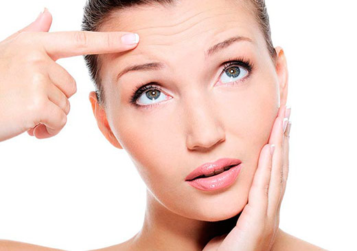 mujer tocando las arrugas de la frente
